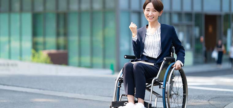 オフィスビルの前にいる車椅子利用者の女性