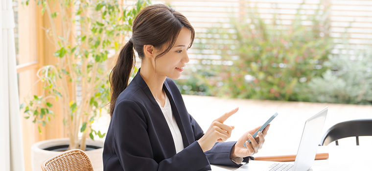 スマホで転職サイトをみる女性のイメージ