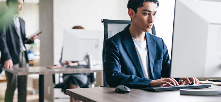 PCでデスクワークをする男性のイメージ