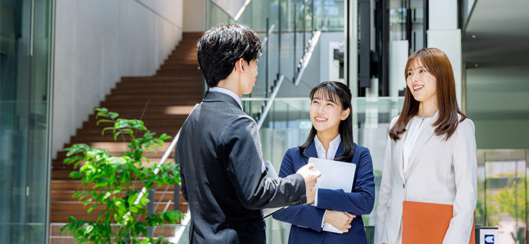 職場で立ち話する男女のイメージ