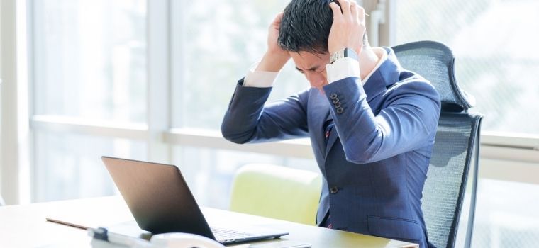 仕事で悩んでいる男性のイメージ